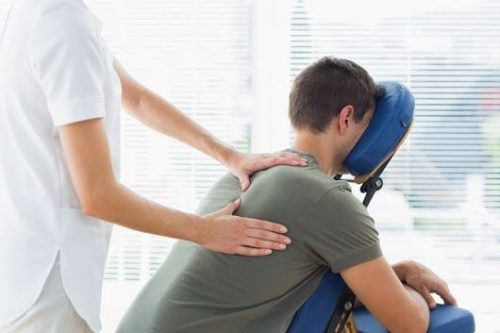 Foto onde um colaborador recebe uma quick massagem em seu expediente de trabalho